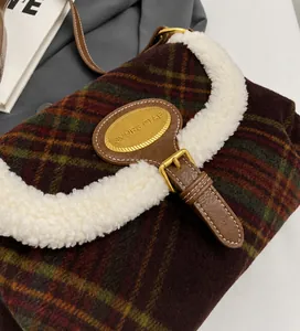 Detail of vintage plaid shoulder bag with faux shearling trim and gold metal hardware