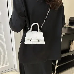 Sac à main minimaliste en similicuir blanc avec bandoulière chaîne sur un modèle