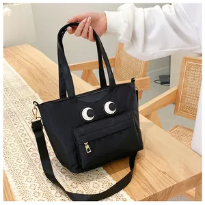 Schwarze Beuteltasche mit großen Augen, Ledergriffen und goldenen Reißverschlüssen