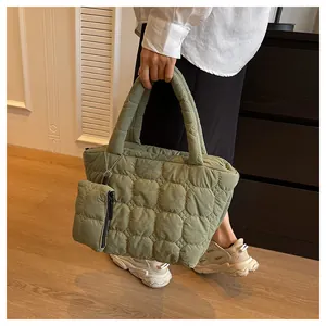 Detailed macro view of olive green quilted tote bag with matching small zipper pouch