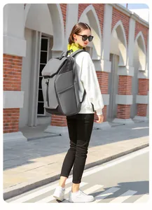 Outdoor shot of a man wearing a grey waterproof business travel backpack in a city street