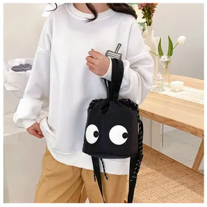 Detail einer schwarzen Nylon-Beuteltasche mit großen Augen in gemütlichem Wohnambiente