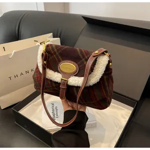 Detail of vintage plaid shoulder bag with white faux shearling trim in a gift box