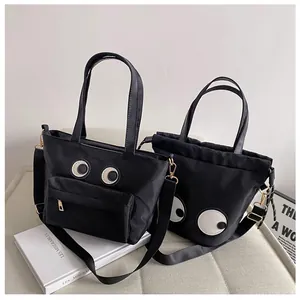Zwei schwarze Nylontaschen mit verspielten großen Augen-Patches und Kordelzug-Design
