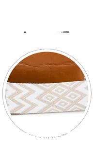 Detail of wide knitted geometric strap and brown crocodile texture on the shoulder bag