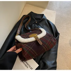 Detail of retro plaid underarm bag with white faux shearling trim on black leather jacket