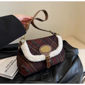 Detail of plaid shoulder bag featuring faux shearling trim and metal logo plaque