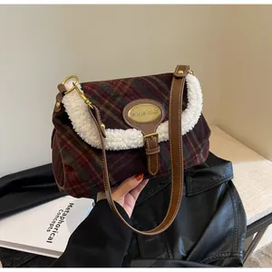 Close-up of retro plaid crossbody bag with faux fur trim and gold metal logo plaque