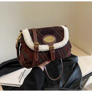 Detail of red-brown plaid shoulder bag with white fleece trim and gold brand plaque