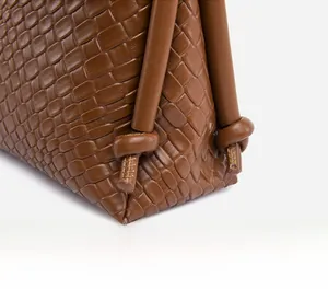 Détails du cuir tressé et des nœuds de bandoulière sur ce sac bandoulière marron