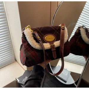 Detail of vintage red-green plaid wool bag with white faux fur trim and gold logo plate