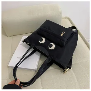 Detailansicht der schwarzen Nylon-Beuteltasche mit Big Eyes Design und Goldreißverschlüssen