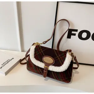 Detail of checkered wool shoulder bag featuring white faux fur trim and gold metal logo plaque