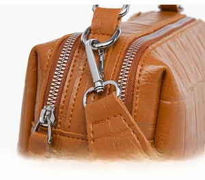 Detail of the brown crocodile pattern leather bag with detachable strap and silver hardware