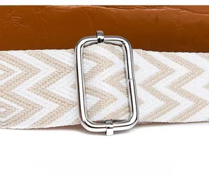 Detail of adjustable woven herringbone strap with silver metal buckle on brown bag