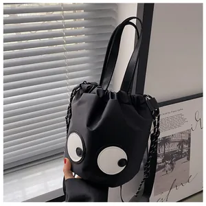 Detail der schwarzen Kordelzug-Beuteltasche aus Nylon mit großen Augen und Webgriff