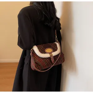 Detail of vintage plaid shoulder bag with plush trim and metallic clasp on a model
