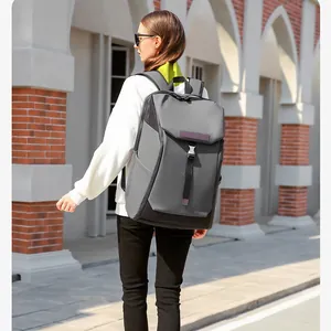 Waterproof dark grey business backpack with metal buckles shown in an outdoor urban setting