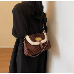 Detailed view of the vintage plaid crossbody bag with shearling trim and metal logo plate