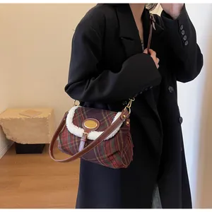 Detail of checkered plaid crossbody bag with faux shearling trim and golden hardware