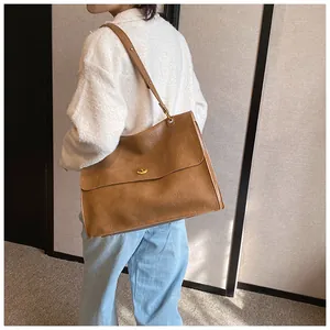 Caramel brown large tote bag with metallic swivel clasp on model for daily commuting