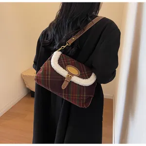 Detail of vintage plaid shoulder bag with soft fleece trim and gold metal logo plaque