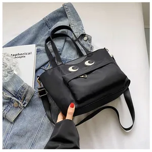 Detailaufnahme der schwarzen Nylon-Eimertasche mit Cartoon-Augen und Gold-Beschlägen