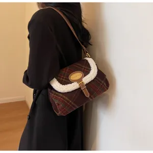 Detail of vintage plaid shoulder bag with faux shearling trim and gold buckle