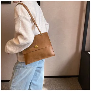 Brown PU leather shoulder bag featuring a classic gold metal rotating flip lock buckle