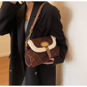 Detail of vintage plaid shoulder bag with faux shearling trim and metal logo buckle