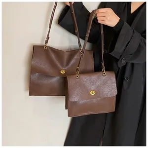 Detail of vintage brown leather bags with golden metal turn-locks on black coat