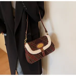 Detail of vintage plaid shoulder bag with plush shearling trim and gold metal logo plate