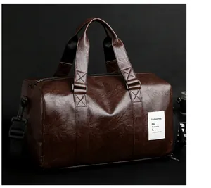 Détail du sac de voyage en cuir marron foncé avec texture litchi et étiquette tissée blanche