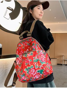 Detailed view of red floral backpack with traditional peony patterns and adjustable straps