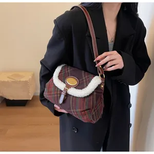Close-up of retro plaid shoulder bag with wool-like trim and brown leather strap