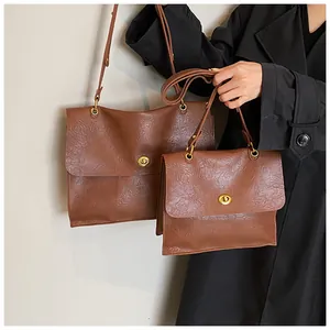 Brown vintage leather shoulder bag detail with gold metal twist lock and wrinkled texture