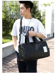 Sac de sport noir en cuir PU avec bandoulière réglable porté par un mannequin en extérieur