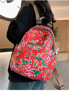 Detailed side view of ethnic floral backpack with red peony pattern and woven straps