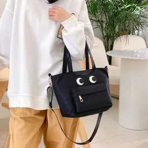 Schwarze Bucket-Bag aus Nylon mit Augen-Design und Reißverschlusstasche für den Alltag