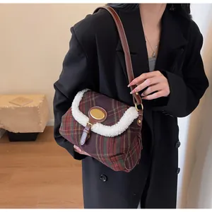 Detailed close-up of retro plaid shoulder bag with wool-like trim and golden emblem