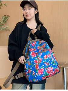 Detailed side view of ethnic floral backpack featuring blue peony print and brown strap
