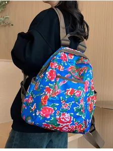 Close-up of vibrant blue backpack with peony floral pattern on a female model