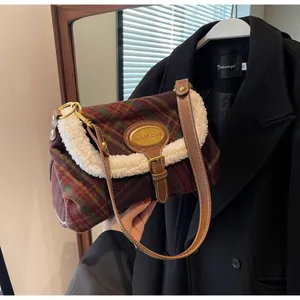 Detail of vintage plaid shoulder bag with wool trim and gold metal logo plaque