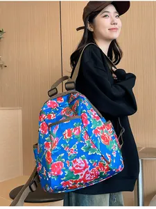 Detailed view of floral backpack with royal blue fabric and pink peony pattern