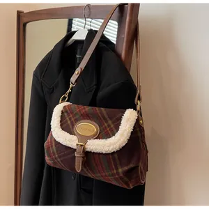 Close-up of vintage brown plaid bag featuring plush faux shearling trim and gold plaque