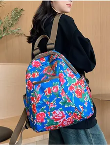 Detail of floral backpack with red peony pattern and adjustable brown canvas straps