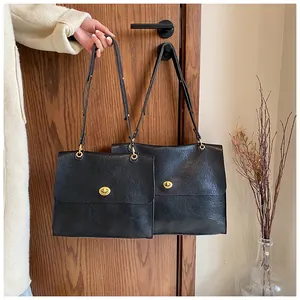 Detail of vintage black leather shoulder bags with elegant gold turn-lock closure