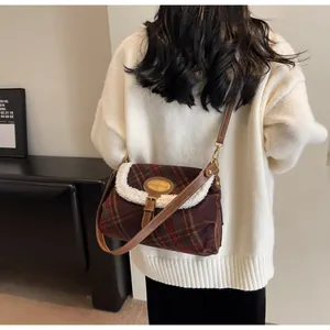 Close-up of retro plaid crossbody bag with warm faux shearling trim and leather strap