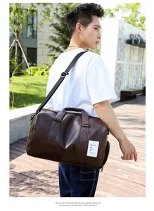 Détail du sac de sport en cuir marron foncé avec bandoulière réglable en extérieur