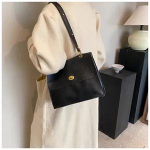Detail view of the black vintage shoulder bag with an oval golden metallic twist lock